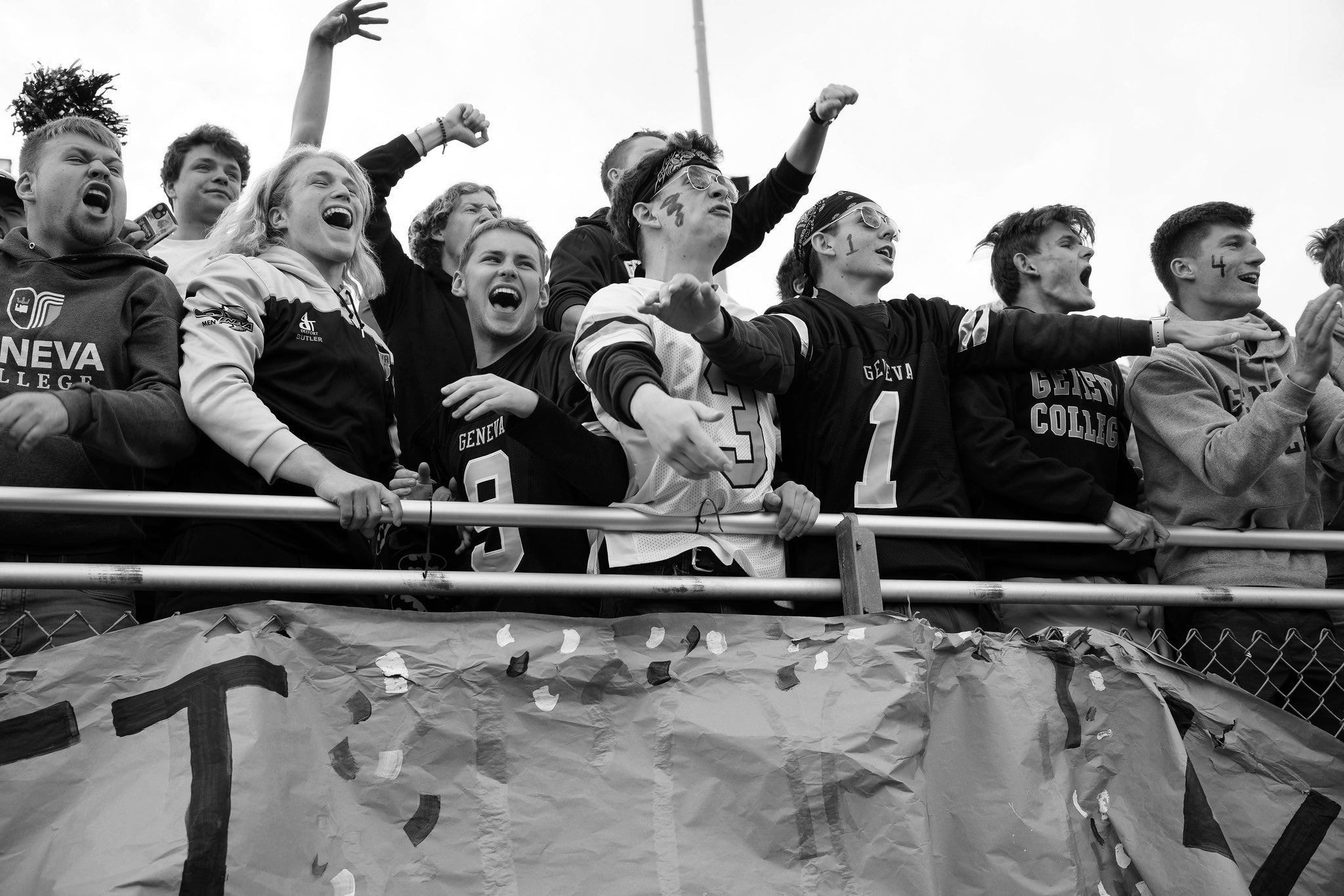 Black and white photo of a group of people cheering.